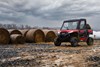 Three-quarter front angle of two people riding a side x side off-road.