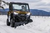 Front angle of a person driving a side x side plowing snow.