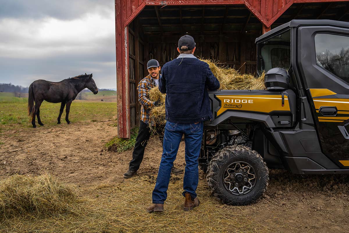 Rear angle of a person loading the back of a side x side.