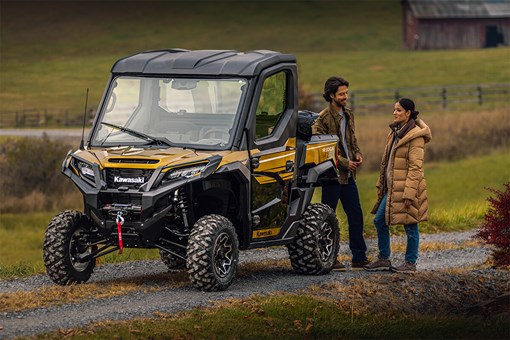 Three-quarter front angle of a parked side x side near two people. opens in a new window
