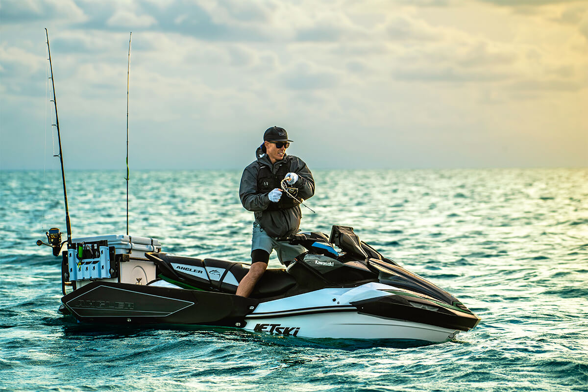 Profile angle of a person standing on a personal watercraft.