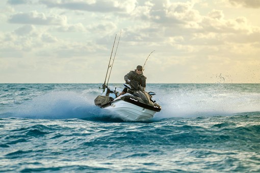 Three-quarter front angle of a person riding a personal watercraft in the ocean. opens in a new window