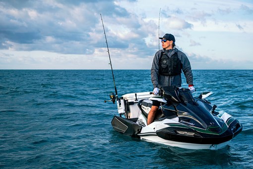 Three-quarter front angle of a person standing on a personal watercraft in the ocean. opens in a new window