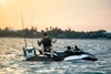 Profile angle of a person seated on a personal watercraft in water.