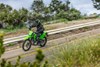 Three-quarter front angle of a person riding a motorcycle on a highway.