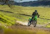 Three-quarter front angle of a person making a turn on a motorcycle off-road.
