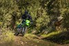 Three-quarter front angle of a person riding a motorcycle off-road.