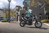 Side angle of a person riding a motorcycle on a city street.