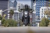 Front angle of a person riding a motorcycle on a city street.