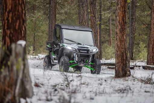 Front angle of a person driving a side x side in the snow. opens in a new window