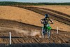Three-quarter front angle of a person riding a motorcycle off-road.