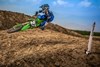 Three-quarter front angle of a person mid air on a motorcycle off-road.