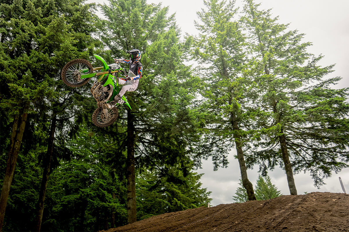 Three-quarter front angle of a person riding a motorcycle in midair.