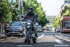 Front angle of a person riding a motorcycle on a city street.