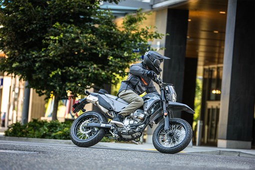 Three-quarter front angle of a person making a turn on a motorcycle on a city street. opens in a new window