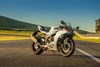 Three-quarter front angle of a parked motorcycle on a racetrack.