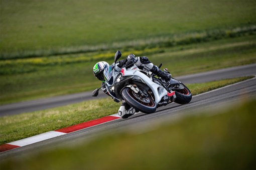 Three-quarter front angle of a person dragging their knee during a turn on a racetrack. opens in a new window
