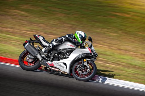 Side angle of a person riding a motorcycle on a racetrack. opens in a new window