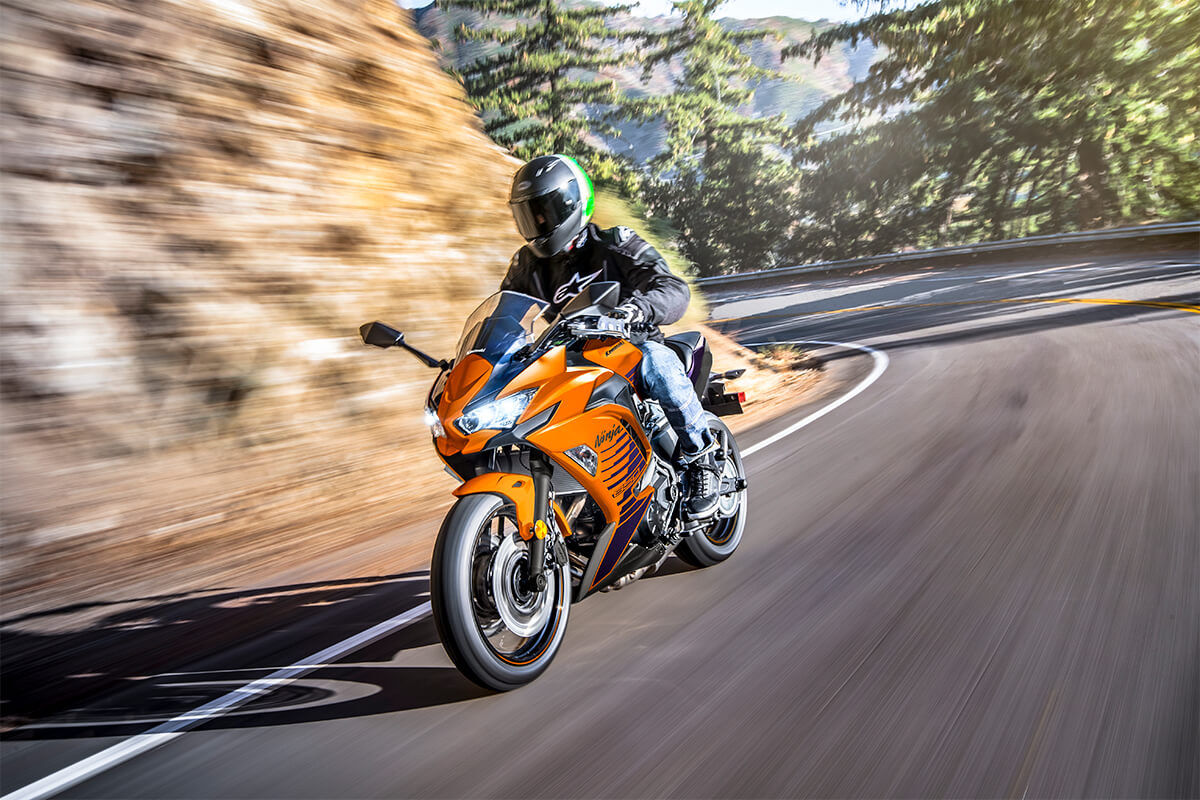 Three-quarter front angle of a person making a turn around a rocky mountain on a highway.