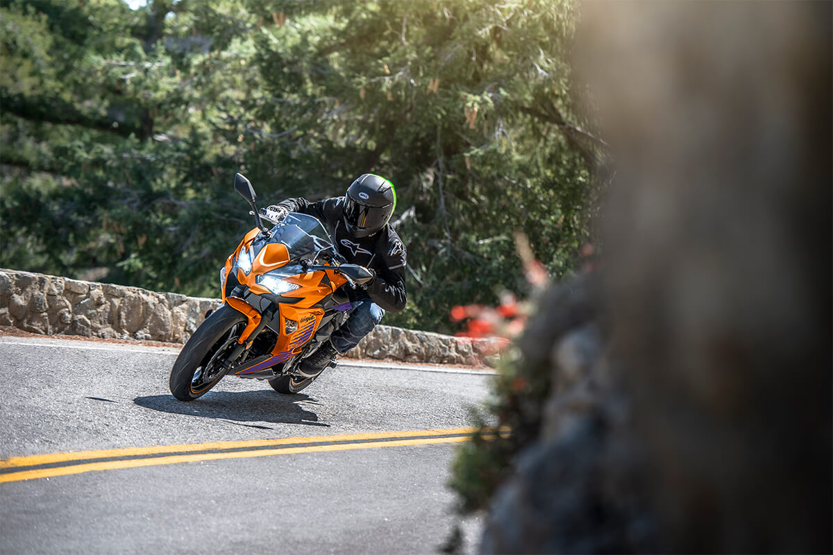Three-quarter front angle of a person riding a motorcycle on a highway.