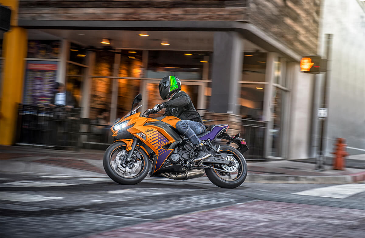 Side angle of a person riding a motorcycle in an urban city.