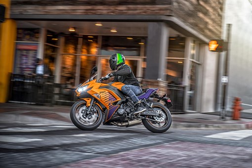 Side angle of a person riding a motorcycle in an urban city. opens in a new window