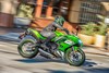 Profile angle of a person riding a motorcycle in an urban city.