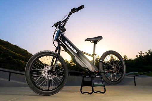 Three-quarter front angle of an electric balance bike parked outside. opens in a new window