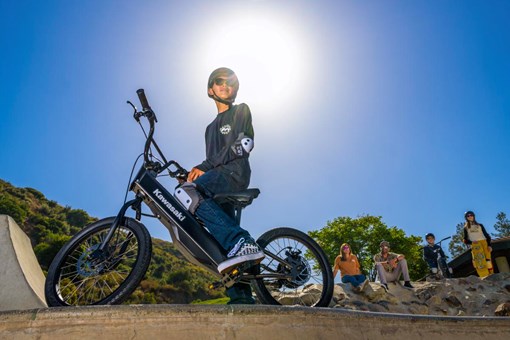 Ground level angle of a young adult sitting on an electric balance bike. opens in a new window