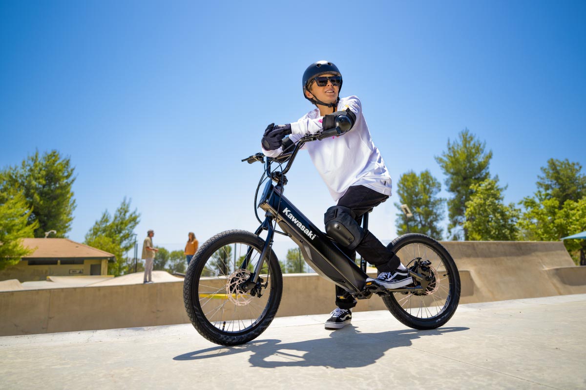 Three-quarter front angle of a young adult sitting on an electric balance bike.