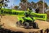 Three-quarter front angle of a person riding an ATV off-road.