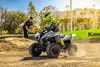 Three-quarter front angle of a person coming out of a turn on an ATV off-road.