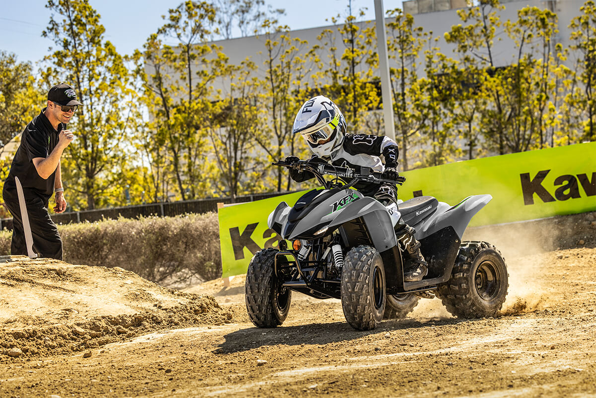 Three-quarter front angle of a person riding an ATV off-road.