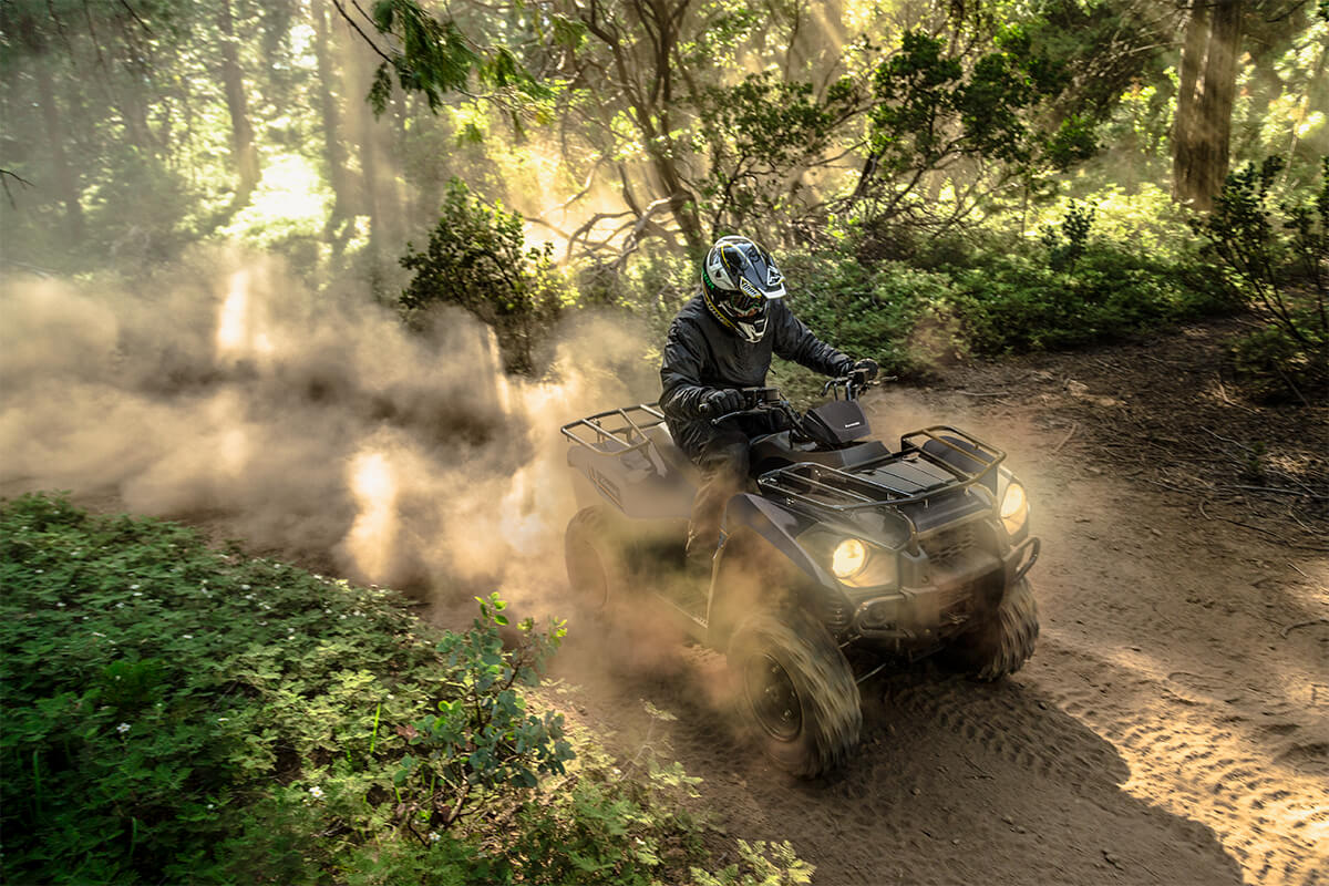 Three-quarter front angle of a person riding an ATV off-road.
