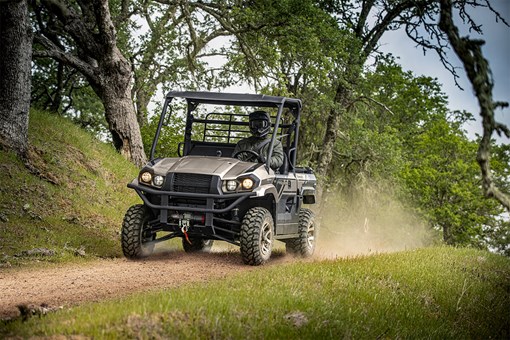 Three-quarter front angle of a person driving a side x side off-road. opens in a new window