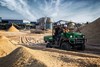 Three-quarter front angle of a person riding an ATV on a job site.