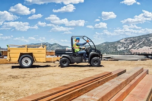 Side angle of a person driving a side x side on a job site. opens in a new window