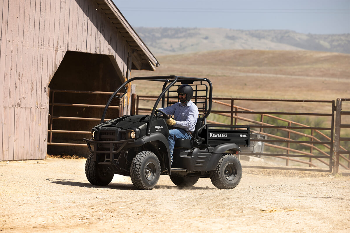 Three-quarter front angle of a person driving a side x side on a ranch.