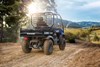 Three-quarter rear angle of a person driving a side x side off-road.