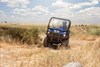 Front angle of a person driving a side x side off-road.