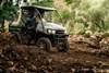 Three-quarter front angle of a person driving a side x side off-road.