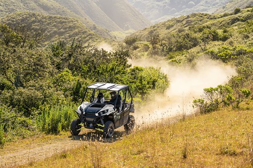 Three-quarter front angle of a person making a turn in a side x side off-road. opens in a new window