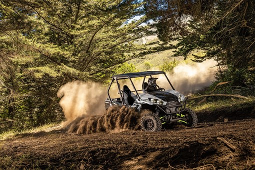 Three-quarter front angle of a person making a sharp turn in a side x side off-road. opens in a new window