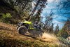 Three-quarter front angle of a person driving a side x side on a dirt trail.