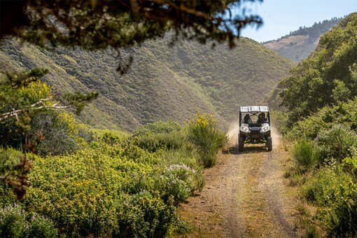 Front angle of a person driving a side x side off-road. opens in a new window