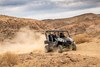 Three-quarter front angle of a person driving a side x side off-road.