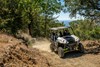 Three-quarter front angle of a person coming out of a turn in a side x side off-road.