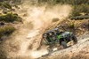 Three-quarter front angle of a person coming out of a turn in a side x side off-road.