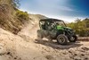 Three-quarter front angle of a person driving a side x side on a dirt trail.