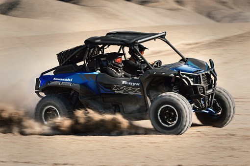 Three-quarter front angle of a person making a sharp turn in a side x side off-road. opens in a new window